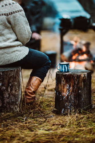 ihminen istuu nuotiolla juoman kanssa kittilan kunta kuva marko vasara web